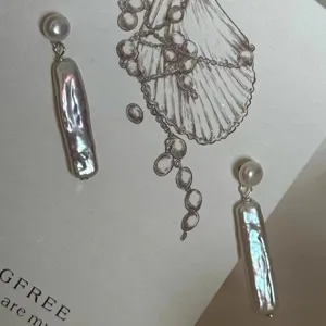 Primer plano detallado de pendientes de perla barroca natural con perno de plata.