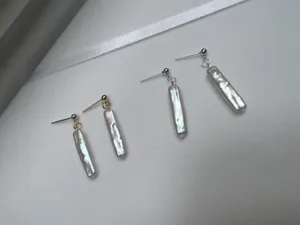 Detalle de primeros planos de pendientes de perlas barrocas naturales con pasadores.