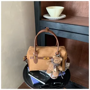 Stilvolle braune Wildleder Boston Tasche mit Metallverschluss und süßem Bären Anhänger.