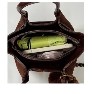Brown suede handbag interior detail showing large storage capacity with daily items inside.