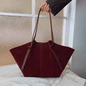 Λεπτομέρεια τσάντας shopper από σκούρο κόκκινο σουέτ, μαλακή υφή, διπλές λαβές και κόμπος.