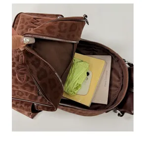 Detail view of brown leopard print velvet backpack, showing interior capacity and zipper pocket.