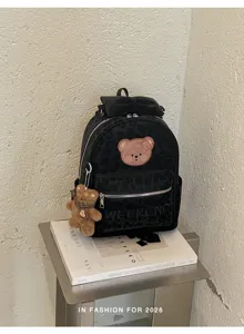 Close-up of black velvet leopard print mini backpack featuring cute bear pendant and bow detail