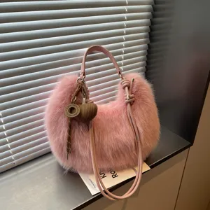 Pink plush shoulder bag detail showing soft faux fur texture and knitted heart charm pendant.