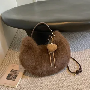 Brown plush shoulder bag detail showing soft furry texture and stylish woven heart charm.