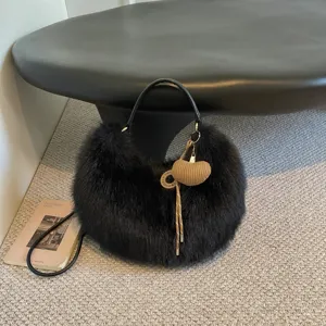 Stylish black plush fluffy shoulder bag with chic woven heart charm and sleek handle for women.