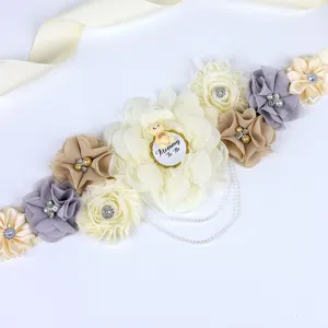 Close-up van babyshower zwangerschapsband bloemdetail met schattige beren en parels.