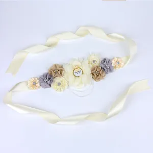 Zwangerschapsgordel voor babyshower feest met stoffen bloemen en Mommy To Be badge.