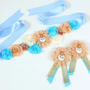 Baby shower zwangerschapsband en corsage set met blauw lint en schattige bloemdecoratie.