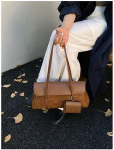 Brown suede and leather baguette shoulder bag with mini pouch, retro chic style.