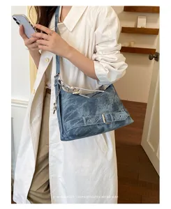 Retro denim shoulder bag for women, casual crossbody pillow bag with chic buckle and metal charm.