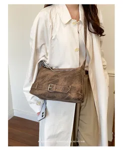 Detail view of retro distressed shoulder crossbody pillow bag with buckle decoration.