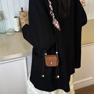 Trendy mini crossbody bag for women, chic brown suede design with beads and scarf.