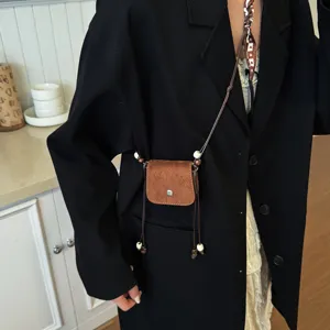 Chic brown suede mini crossbody bag with beaded drawstring strap, trendy womens lipstick bag.