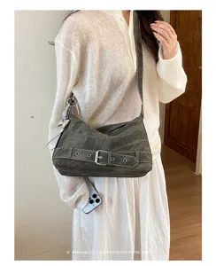 Detail view of vintage retro slouchy shoulder bag featuring stylish front buckle and cute charm.