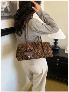 Vista detallada de un bolso Boston de ante con estampado de leopardo y mini estuche.