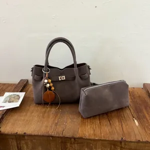Detailed view of the autumn winter suede handbag set with chic twist lock and tassel charm.