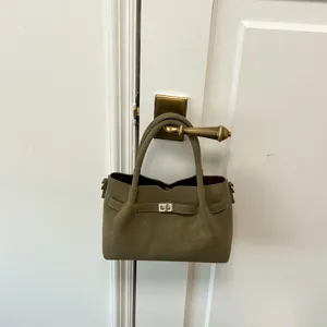 Olive green suede handbag detail, featuring classic turn-lock strap and structured handles.