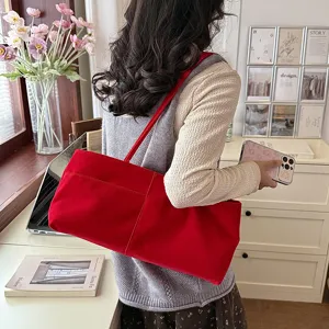 Detail shot of a casual red velvet shoulder bag showcasing large capacity and soft texture.