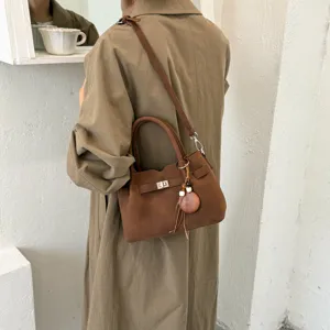 Brown suede retro crossbody shoulder bag featuring a classic turn-lock closure and wooden beads.