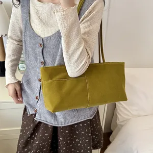 Green velvet shoulder bag detail, featuring soft material, front pocket and dual straps.