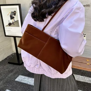 Detailed view of the brown velvet shoulder bag, casual everyday style worn outdoors.