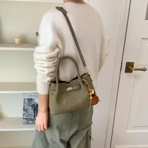 Olive green suede shoulder bag detail, stylish twist-lock closure with bead charm.