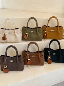 Stylish suede handbag with metal lock and wooden bead charm, versatile shoulder crossbody bag.