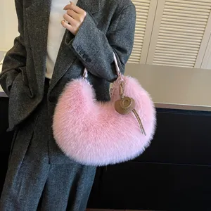 Detailed view of the pink plush crescent shoulder bag with a cute heart charm accessory.