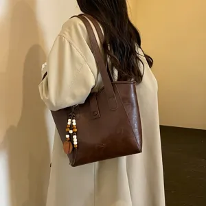 Bolso tote marrón de cuero sintético de gran capacidad con colgante de cuentas de madera.