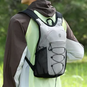Close-up of lightweight grey outdoor backpack, showing mesh pockets and bungee cord details.