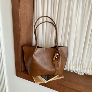 Bolso tote marrón vintage de gran capacidad con doble asa y colgante de cuentas de madera.