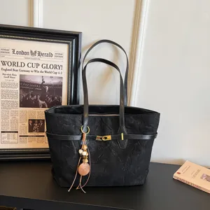 Black large capacity tote bag for women, stylish casual shoulder bag with pendant decor.