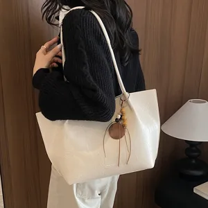 Vista detallada del bolso de hombro blanco casual con colgante, perfecto para el uso diario.