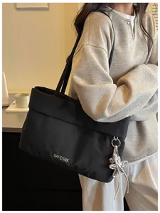 Dettaglio borsa shopper nera capiente, borsa a tracolla in tessuto leggero e minimalista donna