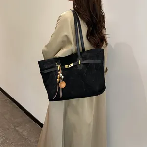 Large capacity black tote bag for women, fashion casual shoulder bag with pendant detail.
