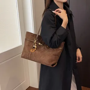 Women large capacity suede shoulder bag chic brown tote bag with wooden charm detail.