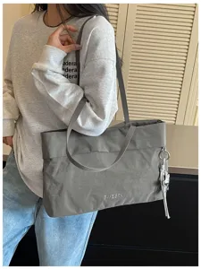 Dettaglio borsa shopper grigia minimal in nylon con grande capienza e struttura morbida.