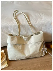 Grande borsa tote bianco crema con ciondolo a stella marina in metallo, comoda borsa in tessuto.