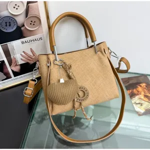 Elegante borsa a tracolla in tessuto cachi da donna con ciondolo a cuore tessuto e manici marroni.