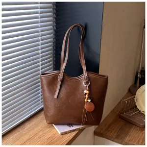 Vista detallada de un elegante bolso tote de cuero marrón, ideal para uso diario y gran capacidad.