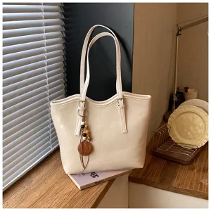 Detalle de bolso tote blanco minimalista, bolso de hombro casual con elegante colgante de madera
