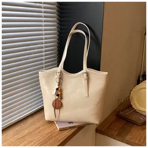Gran bolso de hombro beige minimalista tipo tote con colgante de cuentas de madera para oficina.