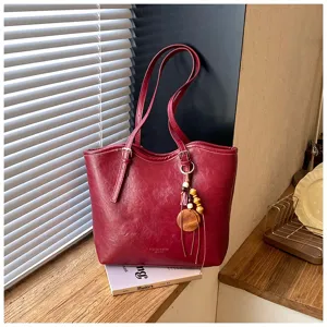 Vista detallada del bolso tote rojo, estilo de vida casual con textura de cuero PU.