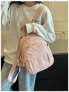 Close-up view of the casual pink daily backpack, showing durable fabric and front pocket detail.