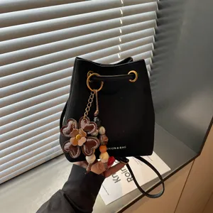 Schwarze Wildleder Beuteltasche mit stilvollem Blumenanhänger und goldener Hardware