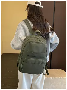 Detailed view of the casual green backpack featuring multiple zip pockets for daily use.