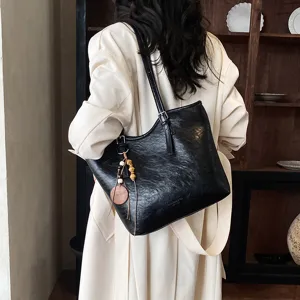 Vista detallada del bolso tote negro grande para mujer, bolso de hombro minimalista de trabajo.