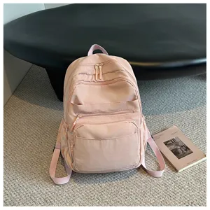 Detailed view of the pink casual backpack showing multi-zipper pockets and durable fabric.
