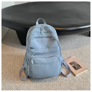 Detailed view of the blue casual backpack with multiple zipper pockets and shoulder straps.